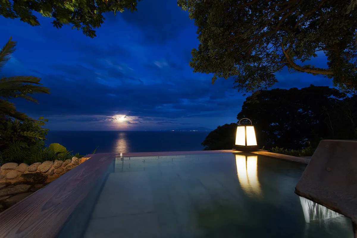 The infinity bath at night with the Moon Road reflection
