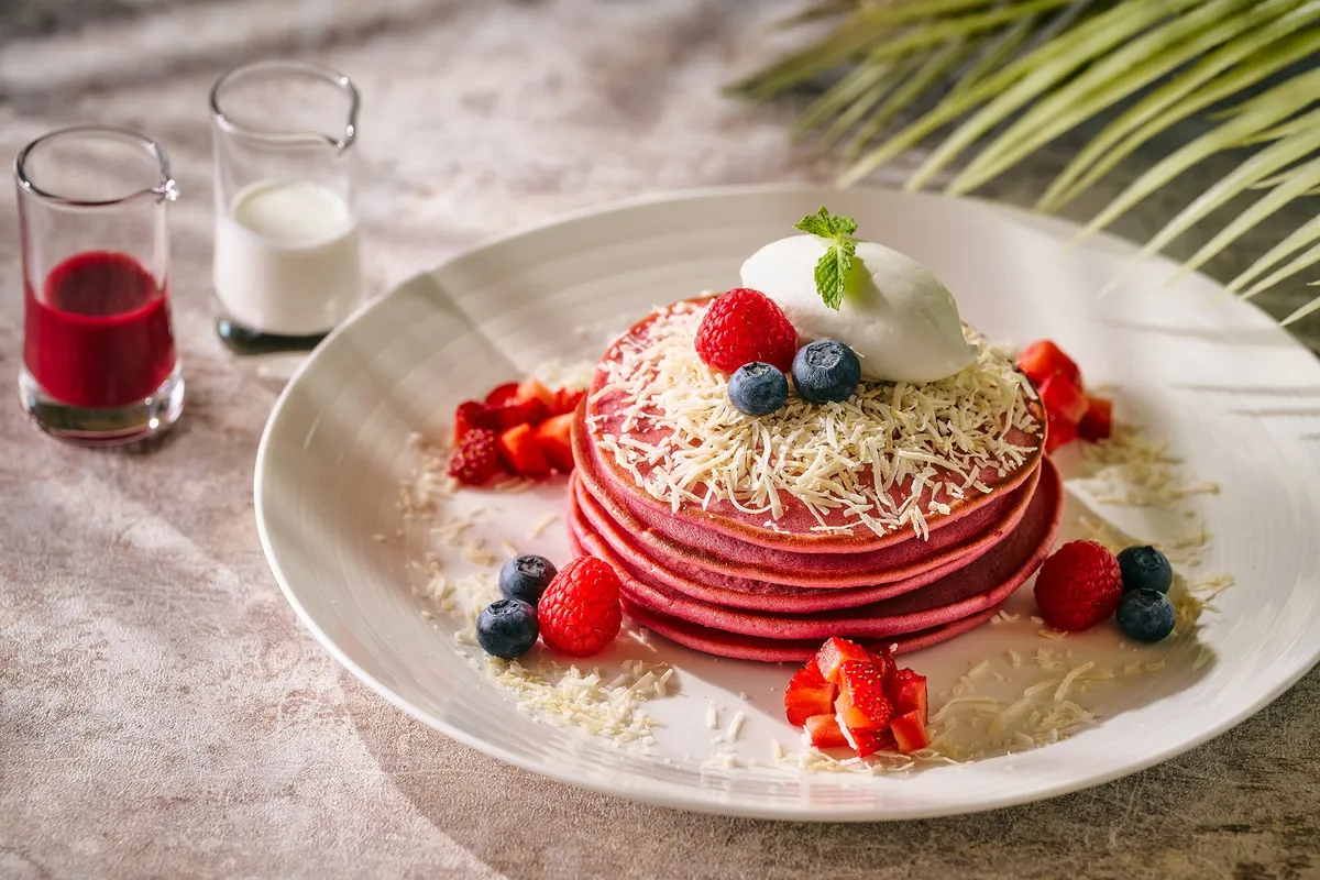 Pink Palace Pancakes topped with fresh berries and cream