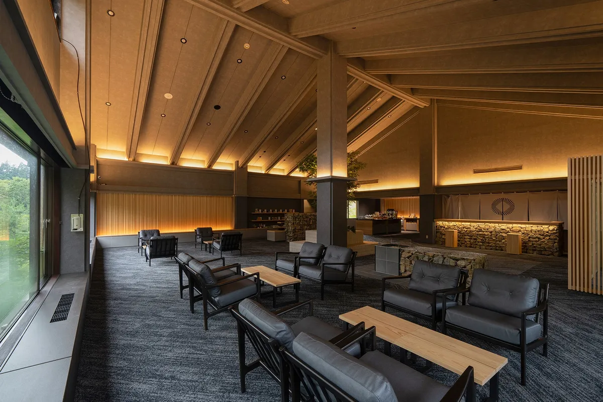 The renovated lounge area with high ceilings and forest views