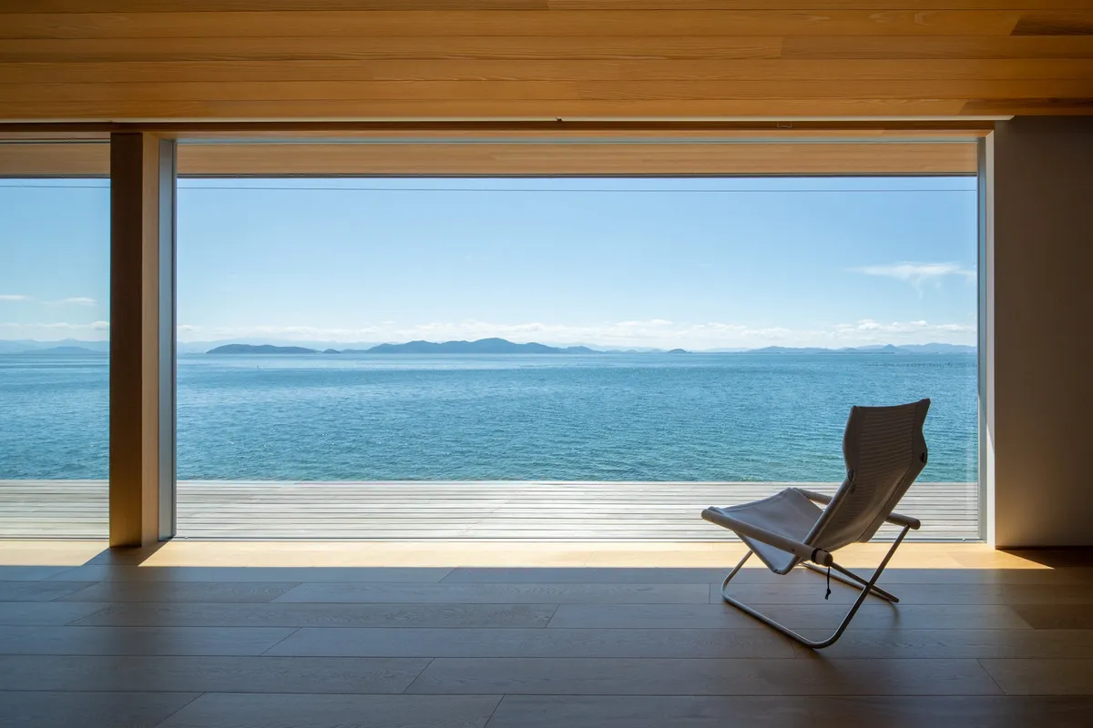 Minimalist interior with a single chair facing Lake Biwa