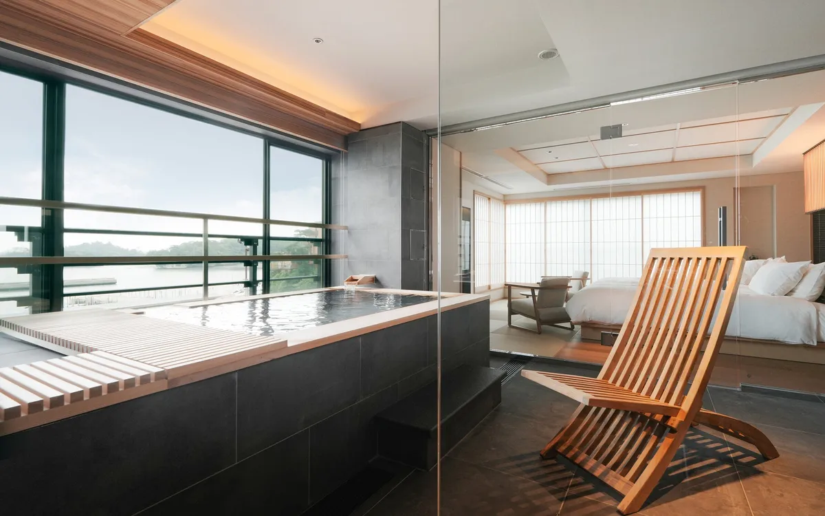 A modern Japanese guest room with a private hot spring bath overlooking the islands of Matsushima.