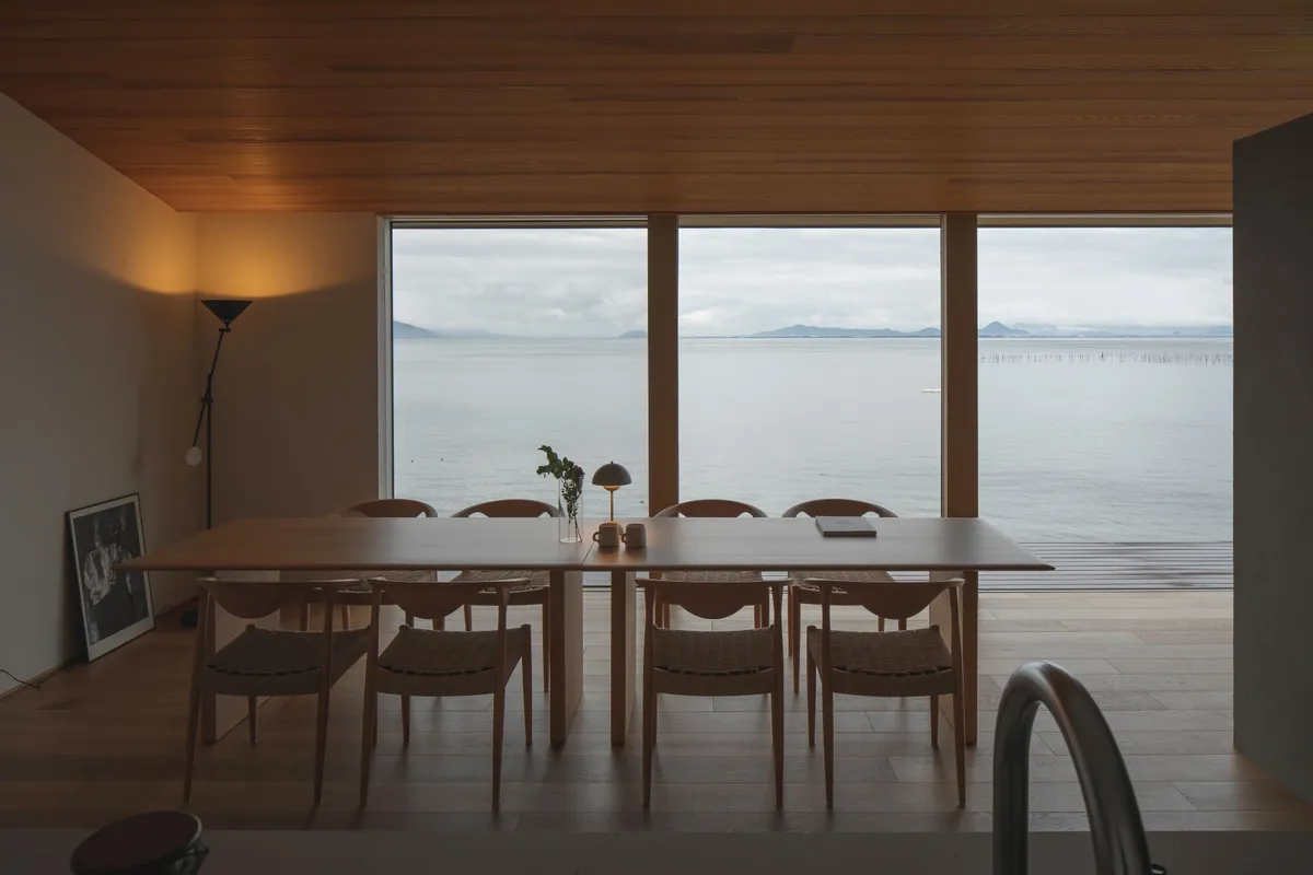 A long wooden dining table overlooking the lake