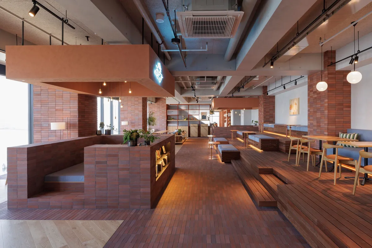 The TAMARIBA public space featuring brick pillars and tiered seating