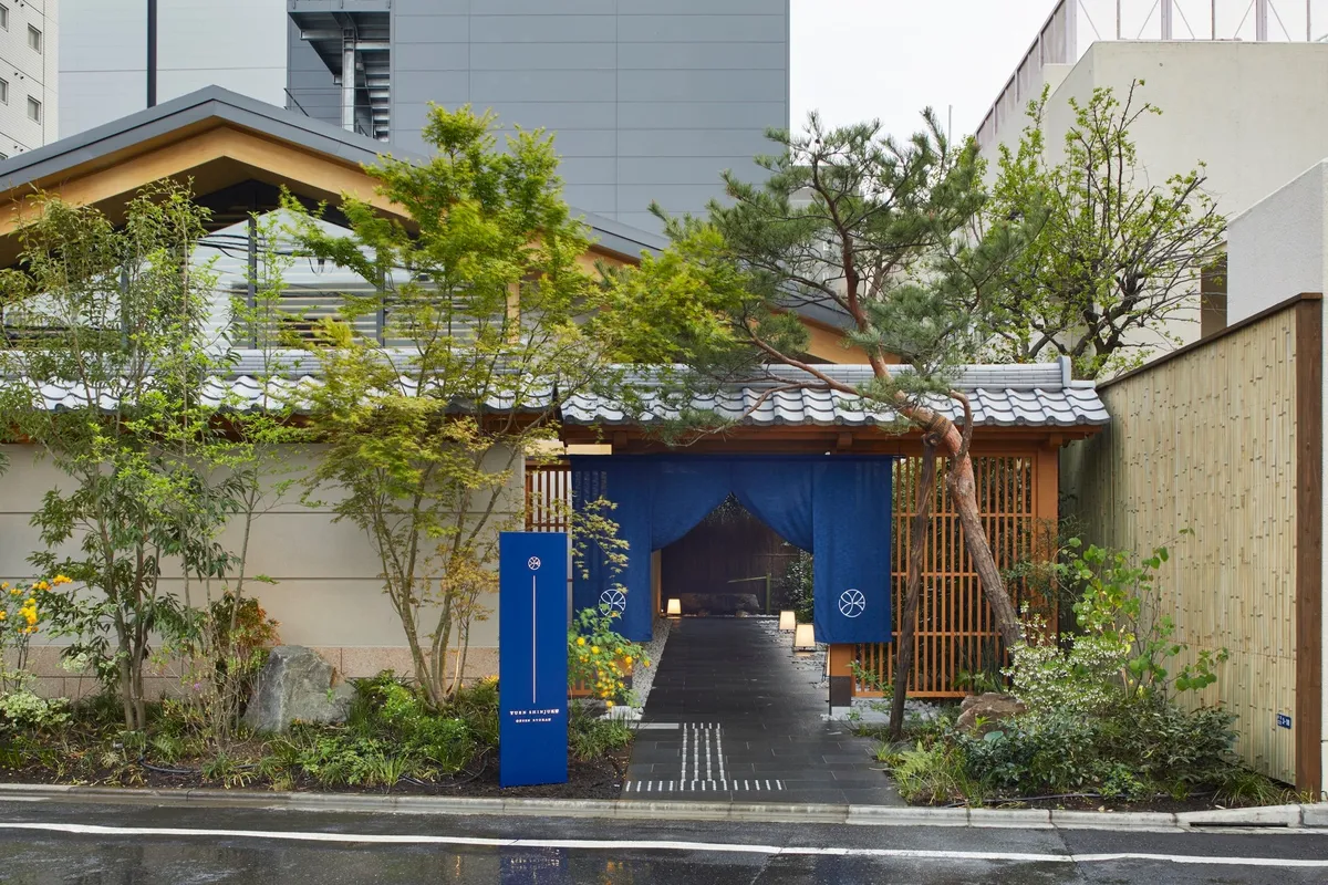 The traditional entrance of ONSEN RYOKAN YUEN SHINJUKU with blue noren curtains
