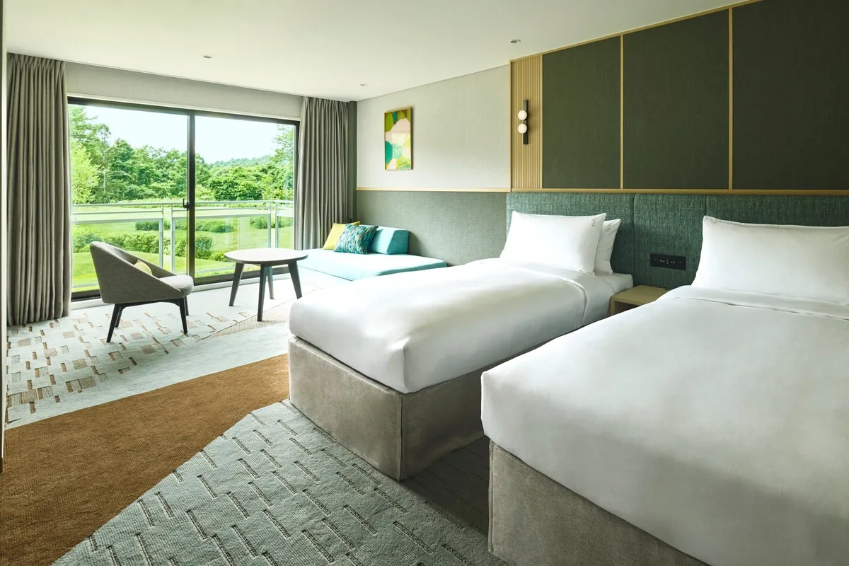 A modern twin guest room with forest views