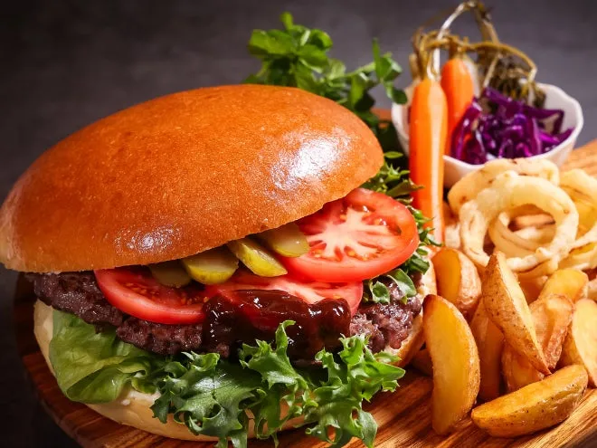 A 200g Hokkaido beef burger served with potato wedges and garnish