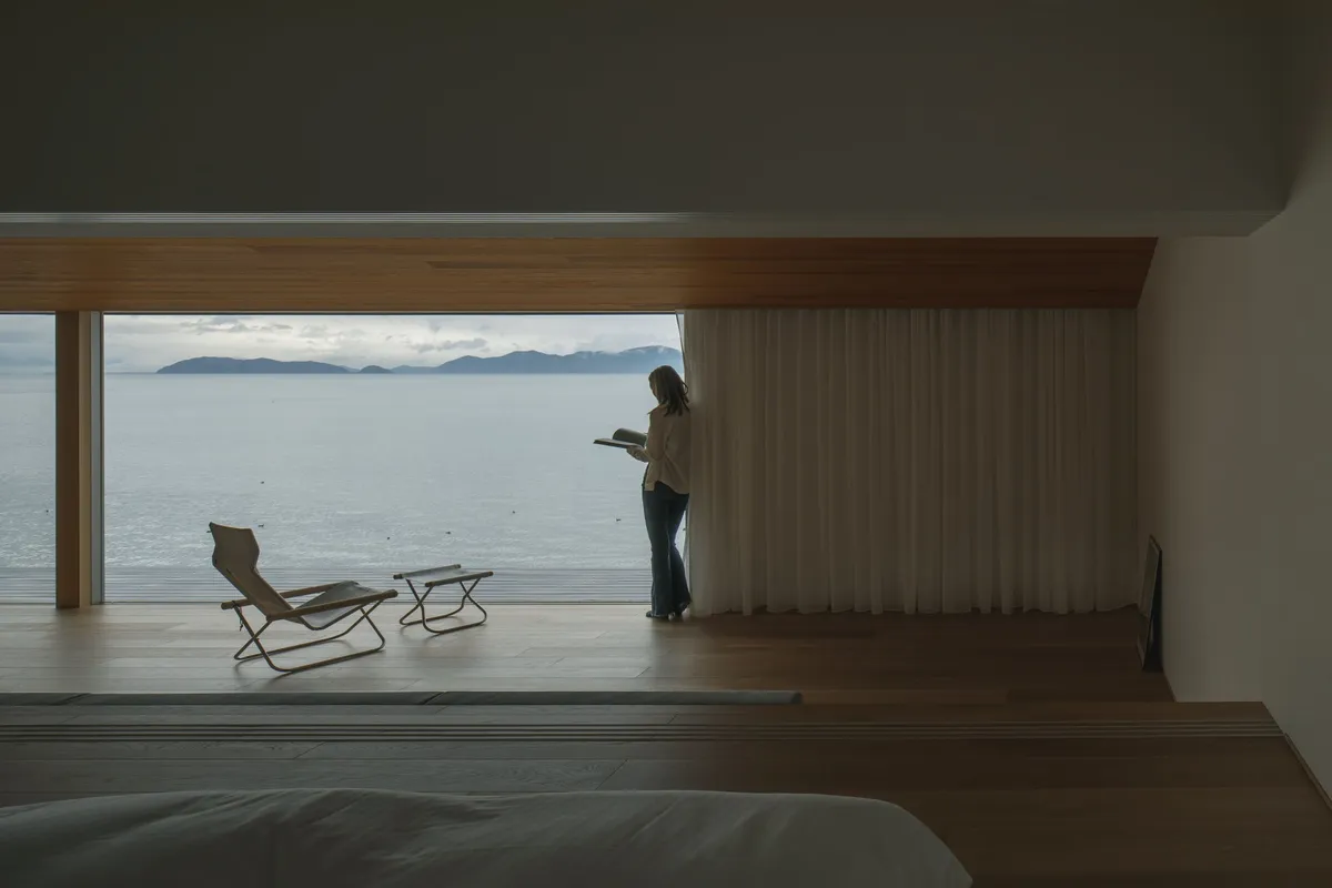 A person reading a book by the window