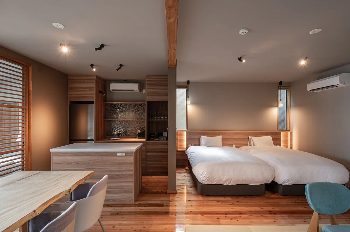 A suite interior combining a modern kitchen island and sleeping area.