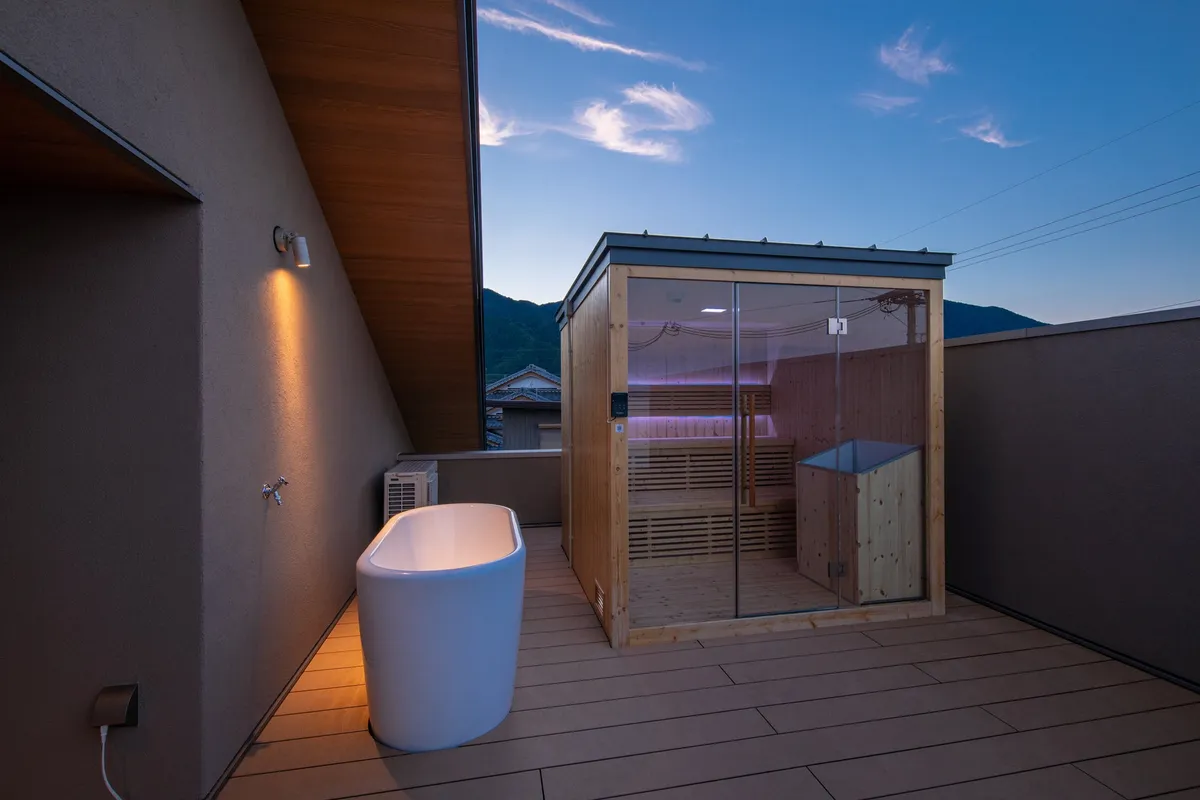 Private sauna and outdoor tub on a terrace at dusk
