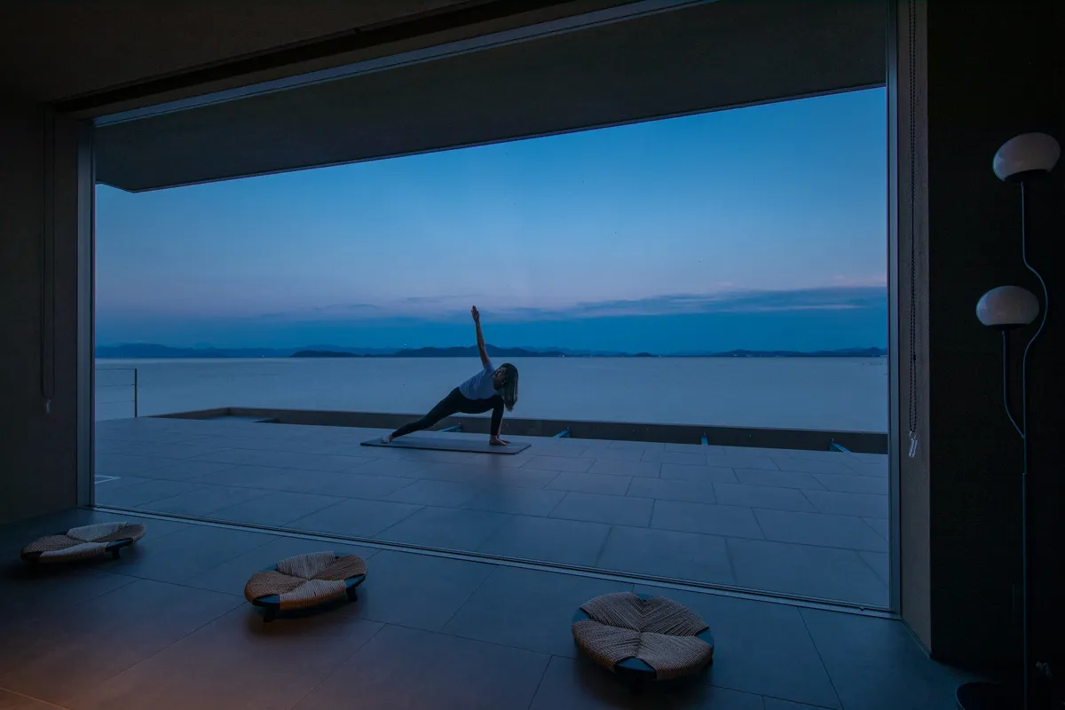 A person practicing yoga on the terrace at night