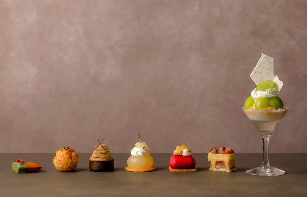 A close-up of autumnal sweets including a Shine Muscat coupe and chestnut tartlets.