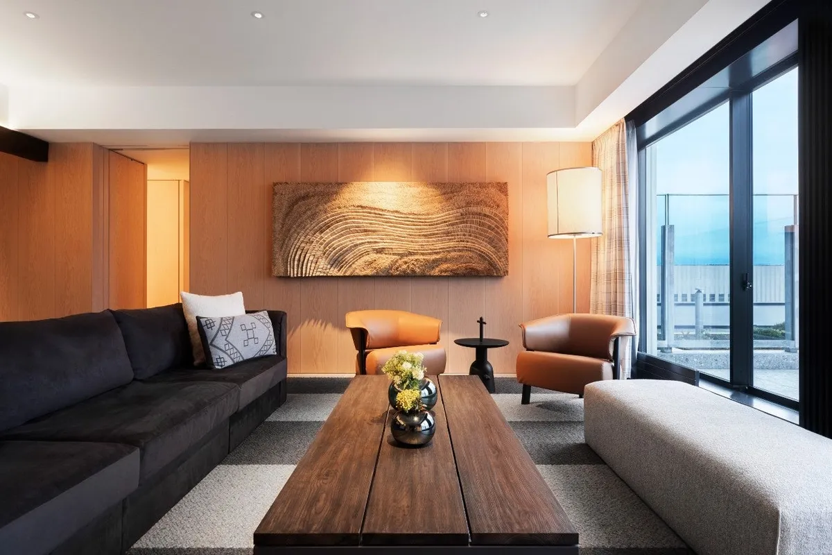Suite living area with textured wall art and natural wood