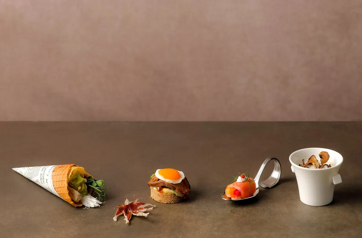 Savory dishes including Omi beef sandwiches and Biwa salmon on a tasting spoon.