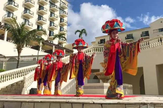 Dancers in traditional Ryukyu costume performing on an outdoor stage
