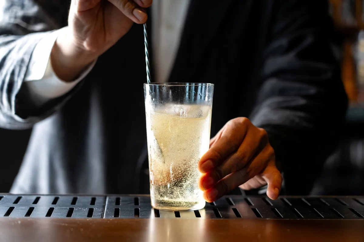 Close-up of a highball being stirred