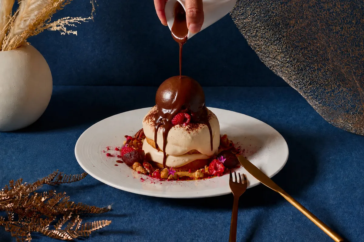 Chocolate sauce poured over a moon-shaped chocolate dome